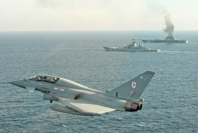 A handout photo made available 25 January 2017 by the British Ministry of Defence showing a Royal Air Force Typhoon shadowing Russian Warships Petr Velikiy (centre) and the Admiral Kuznetsov (background) in the North Sea 24 January. Typhoon aircraft were launched to monitor the Russian warships as they transit close to UK sovereign waters in order to ensure that their activity is monitored and executed safely in accordance with international procedures. (Photo by EPA/MOD Crown Copyright 2017)
