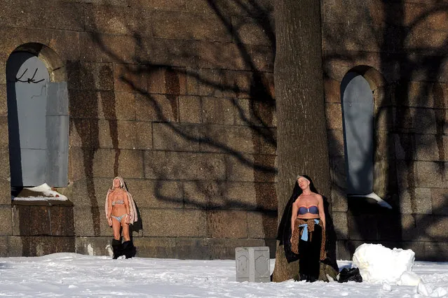 Women enjoy sunbathing at the wall of the Peter and Paul fortress in St. Petersburg on March 1, 2016. (Photo by Olga Maltseva/AFP Photo)