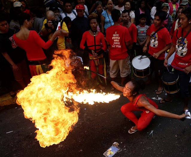 A fire eater performs in front of a business establishment in celebration of Chinese New Year at Manila's Chinatown district of Binondo, Philippines. (Photo by Bullit Marquez/Associated Press)