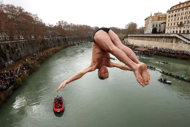 Marco Fois dives into the Tiber River from the Cavour bridge, as part of traditional New Year celebrations in Rome, Italy on January 1, 2024. (Photo by Guglielmo Mangiapane/Reuters)
