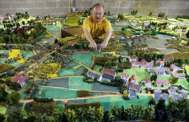 Waterloo enthusiast Willy Smout, 56, adjusts figurines on a 40-square-metre miniature model of the June 18, 1815 Waterloo battlefield, in Diest, Belgium, in this picture taken on April 29, 2015. (Photo by Francois Lenoir/Reuters)