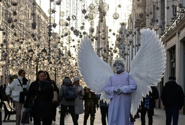 A man dressed as an angel stands in a street amid the outbreak of the coronavirus disease (COVID-19) in Moscow, Russia on October 26, 2021. (Photo by Evgenia Novozhenina/Reuters)