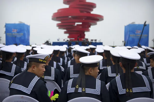 Chinese sailors sit during a concert featuring Chinese and foreign military bands in Qingdao, Monday, April 22, 2019. Ships from Chinese and foreign navies have gathered in Qingdao for events this week, including a naval parade, to mark the 70th anniversary of the founding of the People's Liberation Army (PLA) Navy. (Photo by Mark Schiefelbein/AP Photo)