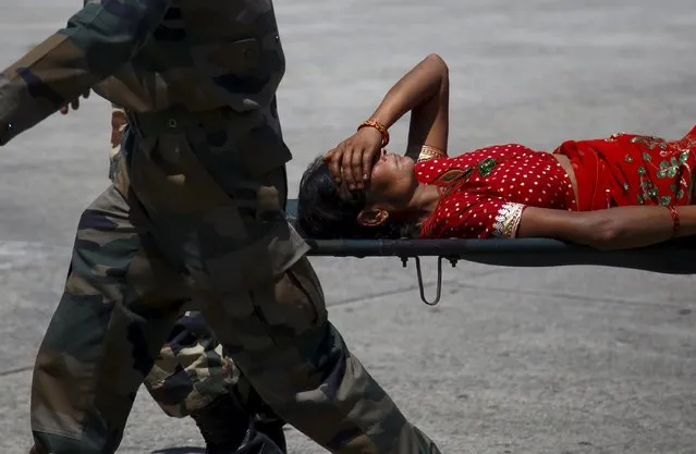 An earthquake victim is carried in a stretcher after being airlifted from Ramechhap District, at Tribhuvan International Airport in Kathmandu May 14, 2015. (Photo by Navesh Chitrakar/Reuters)