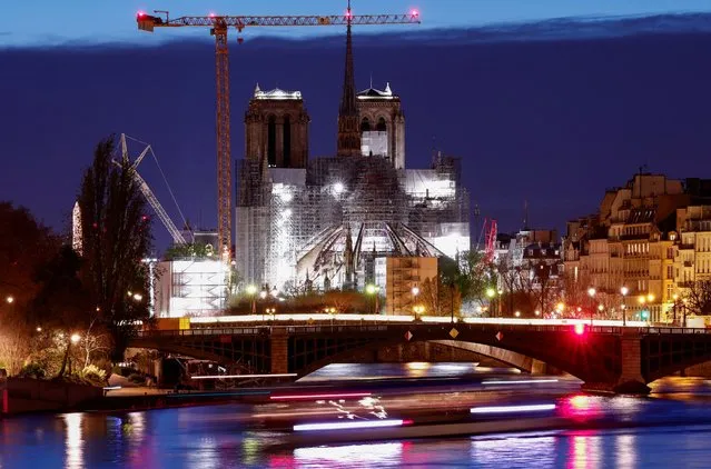 A tourist boat travels on the River Seine near the Notre-Dame de Paris Cathedral, which was ravaged by a fire in 2019, as restoration works continue in Paris, France on March 31, 2024. (Photo by Gonzalo Fuentes/Reuters)