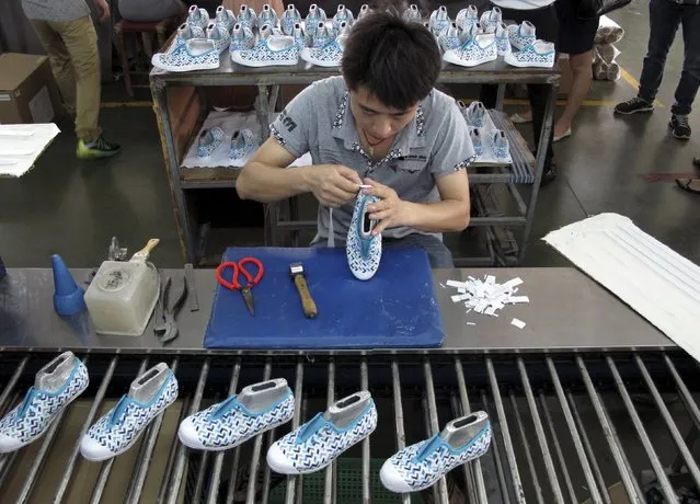 An employee works at a Shuangwei factory in Putian, Fujian province, China, May 14, 2015. Criticised and even sued by luxury brand Gucci and others for facilitating the counterfeit goods trade, Chinese e-commerce giant Alibaba Group Holding Ltd has been quietly piloting a scheme to try to curb fakes at source. (Photo by John Ruwitch/Reuters)