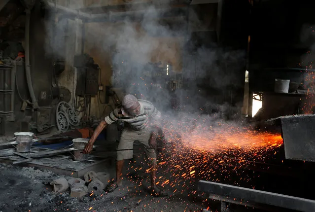 A worker clears a furnace at an iron casting factory in Ahmedabad, India March 1, 2017. (Photo by Amit Dave/Reuters)