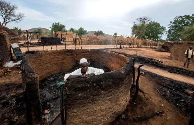 A man is seen inside a burnt house during clashes between nomads and residents in Deleij village, located in Wadi Salih locality, Central Darfur, Sudan on June 13, 2019. (Photo by Reuters/Stringer)