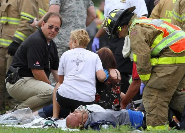 Rescue personnel treat passengers from a charter bus that was hit by a CSX train at the Main Street crossing in Biloxi, Miss., on Tuesday, March 7, 2017. The bus was carrying 50 people from Austin, Texas, Biloxi Police Chief John Miller said at a news conference. He said authorities believe the bus was stopped on the tracks at the time of the crash, but they don't yet know why. (Photo by John Fitzhugh/The Sun Herald via AP Photo)