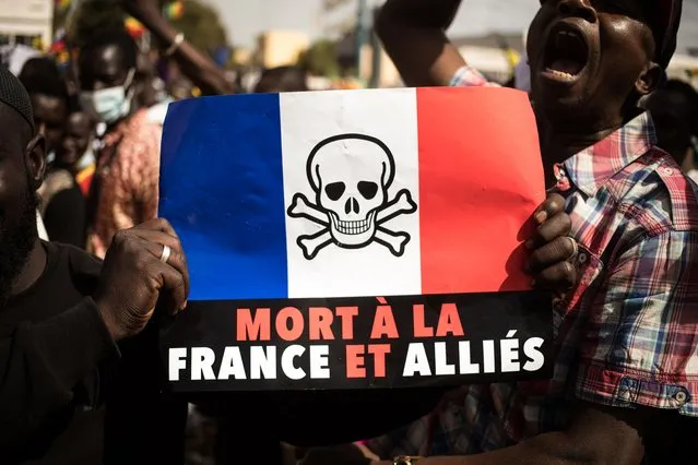 Demonstrators hold up a that reads, “Death to France and its allies”, during a mass demonstration to protest against sanctions imposed on Mali and the Junta, by the Economic Community of West African States (ECOWAS), in Bamako on January 14, 2022. Malians took to the streets on January 14, 2022, after the military junta called for protests against stringent sanctions  imposed by the West Africa bloc ECOWAS over delayed elections. (Photo by Florent Vergnes/AFP Photo)