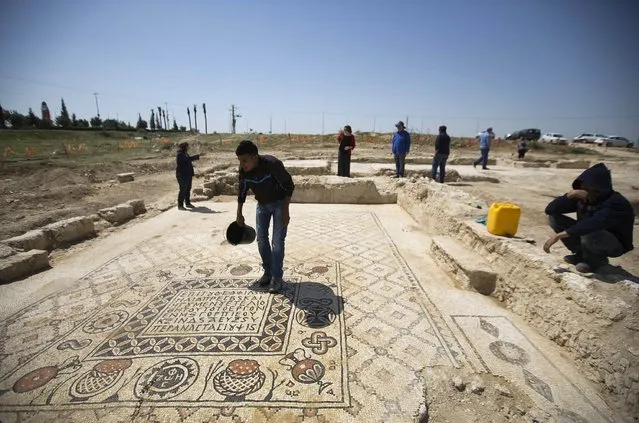 A worker for the Israel Antiquities Authority (IAA) stands on the mosaic floor of a monastery unearthed during excavations in Hura, east of Beersheba April 1, 2014. The IAA said on Tuesday that the Byzantine-era monastery and the mosaic floor were discovered during a salvage dig ahead of construction of an interchange. (Photo by Amir Cohen/Reuters)