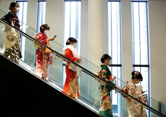 Women wearing kimono and protective masks ride on an escalator at Coming of Age Day celebration ceremony venue, amid the coronavirus disease (COVID-19) outbreak, in Tokyo, Japan, January 10, 2022. (Photo by Kim Kyung-Hoon/Reuters)