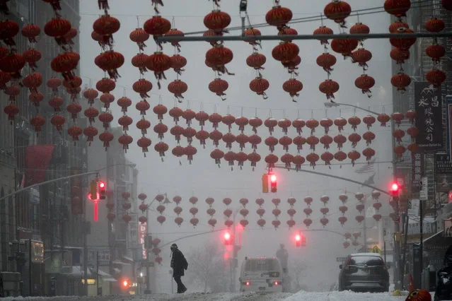 A pedestrian crosses East Broadway during a snowstorm, Tuesday, March 14, 2017, in the Chinatown neighborhood of New York. (Photo by Mary Altaffer/AP Photo)