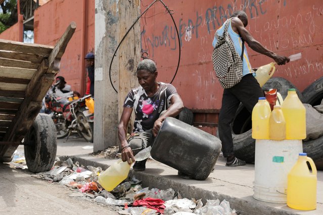 A fuel vendor pours gasoline, in Port-au-Prince, Haiti on May 1, 2024. (Photo by Ralph Tedy Erol/Reuters)