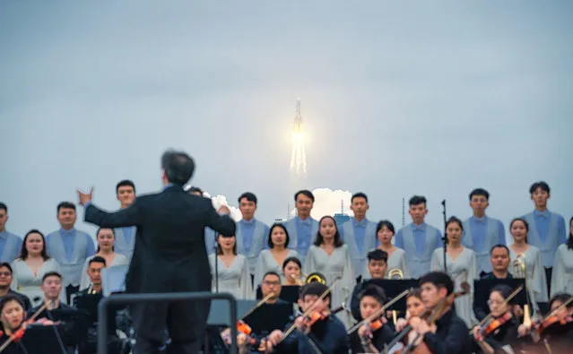 Members of Xi'an Symphony Orchestra perform at a beach as a Long March-5B Y2 rocket carrying the core module of China's space station, Tianhe, blasts off from the Wenchang Spacecraft Launch Site on April 29, 2021 in Wenchang, Hainan Province of China. (Photo by Zhu Entong/VCG via Getty Images)