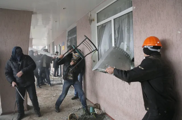 Pro-Russian men storm a police station in the eastern Ukrainian town of Horlivka on Monday, April 14, 2014.  Several government buildings have fallen to mobs of Moscow loyalists in recent days as unrest spreads across the east of the country. (Photo by Efrem Lukatsky/AP Photo)