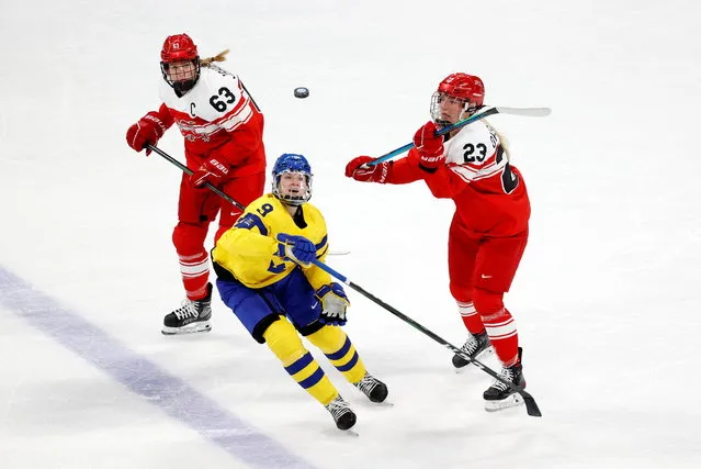Jessica Adolfsson of Sweden go for the puck with Julie Oksbjerg of Denmark and Josefine Jakobsen of Denmark during the women's preliminary round group B match of 2022 Beijing  Olympics ice hockey competition between Sweden and Denmark at the Wukesong Sports Center on February 8, 2022. (Photo by David W. Cerny/Reuters)