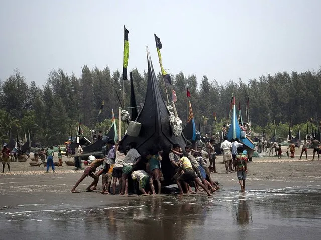 People push a boat to land in the Shamalapur Rohingya refugee settlement in Chittagong district. (Photo by Getty Images/Stringer)
