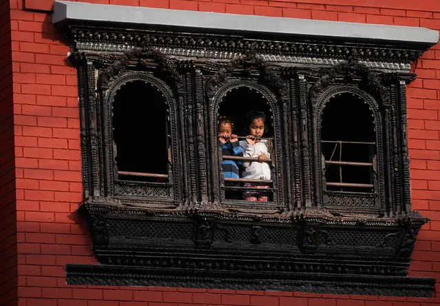 Nepalese children watch Seto Machindranath chariot festival in Kathmandu, Nepal, Tuesday, April 4, 2017. Hindu and Buddhist worshippers participate in the week-long chariot festival, praying for rainfall and good harvest. (Photo by Niranjan Shrestha/AP Photo)