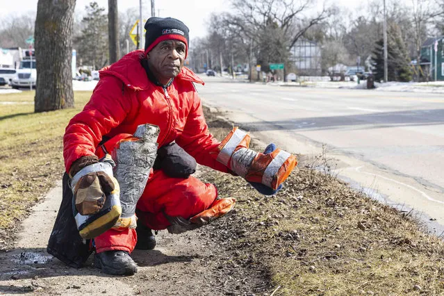 Bobby Holley, 76, prepares to cross the street as the sidewalk along M-89 was covered in mud and water in Calhoun County, Mich., Monday, February 21, 2022. Holley is crawling 21 miles, from Battle Creek to downtown Kalamazoo to protest gun violence. Holley started his crawl at 10 a.m., Feb. 21 and estimates he will reach Kalamazoo on Feb. 23. (Photo by Joel Bissell/MLive.com/Kalamazoo Gazette via AP Photo)