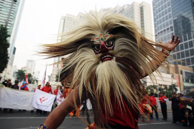 A masked dancer performs during a May Day rally at the business district in Jakarta, on May 1, 2014. (Photo by Reuters/Beawiharta)