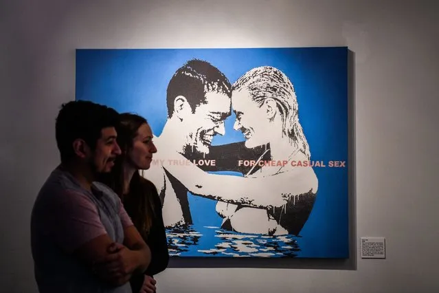 People look at works by British artist Banksy displayed during the exhibition “The Art of Banksy: Without Limits” in Miami, Florida on February 2, 2022. (Photo by Chandan Khanna/AFP Photo)