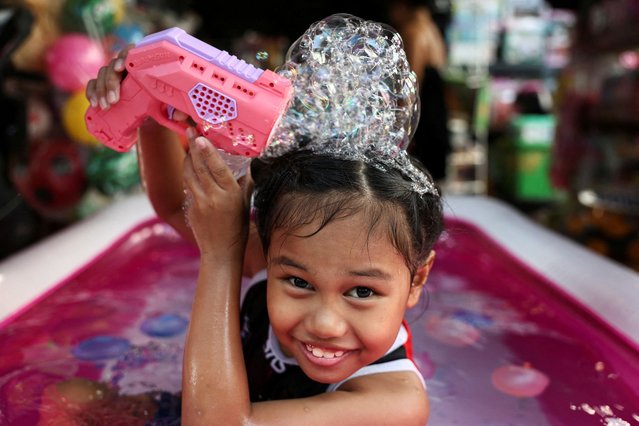 Wattanavipha Subsri, 8, plays with water in a bath in front of her home to cool down as Thai authorities said that people were dying from heat stroke this year and warned to avoid outdoor activities, in Bangkok, Thailand on May 5, 2024. (Photo by Chalinee Thirasupa/Reuters)