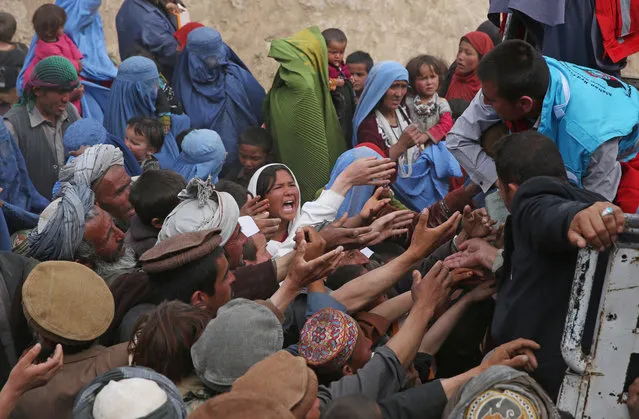 Survivors try to get some donations near the site of Friday's landslide that buried Abi Barik village in Badakhshan province, northeastern Afghanistan, Monday, May 5, 2014. As Afghans observed a day of mourning Sunday for the hundreds of people killed in a horrific landslide, authorities tried to help the 700 families displaced by the torrent of mud that swept through their village. (Photo by Massoud Hossaini/AP Photo)