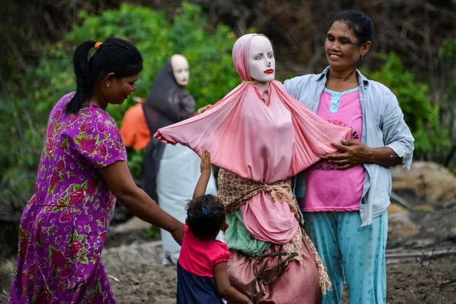 This picture taken on August 26, 2019 shows villagers setting up a mannequin scarecrow on a paddy field in Lamteuba, Indonesia's Aceh province. (Photo by Chaideer Mahyuddin/AFP Photo)