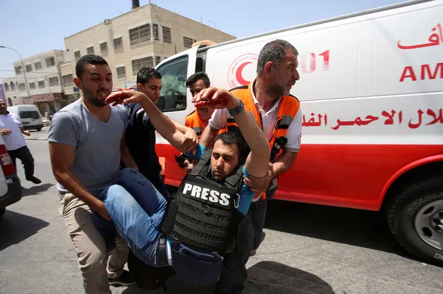 A wounded photographer is evacuated during clashes between Palestinians and Israelis near the Hawara checkpoint near the West Bank city of Nablus on May 18, 2017. (Photo by Reuters/Stringer)