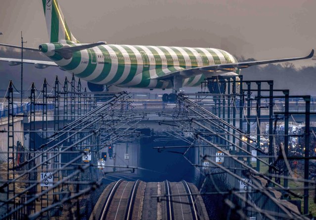 A Condor aircraft rolls on a bridge over a railway line in Frankfurt, Germany, Wednesday, March 6, 2024. German Lufthansa airline and the train drivers union GDL called for strikes starting on Thursday. (Photo by Michael Probst/AP Photo)