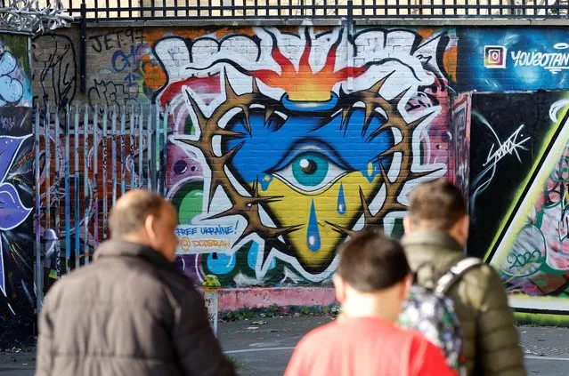 People walk past artwork in support of Ukraine, as Russia's invasion of Ukraine continues, London, Britain, March 24, 2022. (Photo by Peter Cziborra/Reuters)