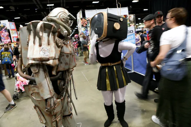Roxanna Childs (L), 49, from Richmond, Va., who is dressed as T60 Power Armor from Fallout 4, plays with Michaela Swain (R), 19, from Reston, Va., who is dressed as Venthizonxa, at AwesomeCon at the Walter E. Washington Convention Center in Washington, DC on June 17, 2017. (Photo by Linda Wang/The Washington Post)
