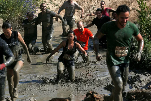 Participants compete in the Mud Day Race extreme run competition at El Goloso military base, outside Madrid, Spain, June 11, 2016. (Photo by Juan Medina/Reuters)