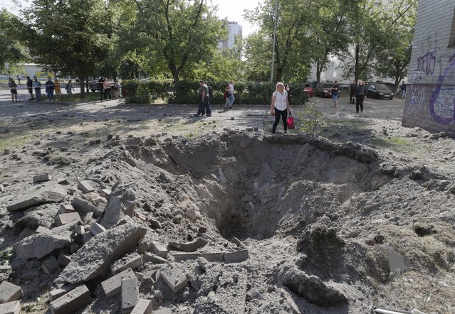 A person stands next to a shell crater near a residential building after a missile strike in Kyiv (Kiev), Ukraine, 01 June 2023, amid the Russian invasion. At least three people died, including a child, and ten others were injured after a missile attack on the Ukrainian capital, the National Police said. Russian troops entered Ukrainian territory in February 2022, starting a conflict that has provoked destruction and a humanitarian crisis. (Photo by Sergey Dolzhenko/EPA)