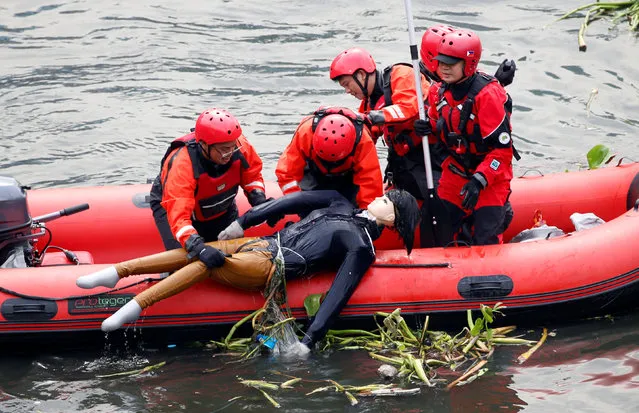 Rescuers retrieve a mannequin (a simulated earthquake casualty) from a murky river, during a metrowide earthquake drill along main highway EDSA in Makati, Metro Manila, Philippines June 22, 2016. (Photo by Erik De Castro/Reuters)