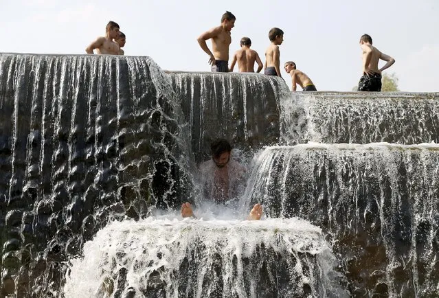People cool down in a channel during a hot day in Minsk August 11, 2015. Hot weather hit Belarus as the temperature rose to 33 degrees Celsius (91.4 degrees Fahrenheit), according to local media. (Photo by Vasily Fedosenko/Reuters)