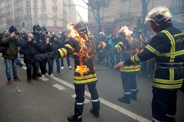 French firefighters simulate setting themselves on fire during a demonstration to protest against working conditions, in Paris, France, January 28, 2020. Police fired tear gas and hit protesters with batons as firefighters demonstrated against working conditions and demanded more pay in Paris, amid widespread labor unrest across France. (Photo by Charles Platiau/Reuters)