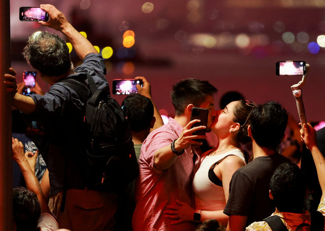 A couple kiss as people watch the Macy's Fourth of July fireworks in New York City, U.S., July 4, 2023. (Photo by Amr Alfiky/Reuters)