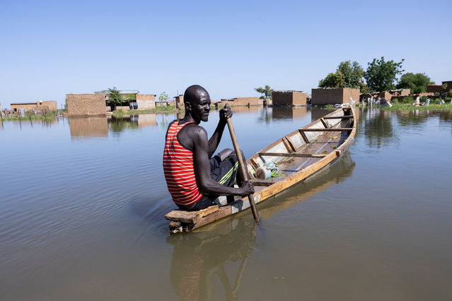 A man navigates a pirogue between the houses of the Tougoude district, in the south-east of Ndjamena's ninth arrondissement, flooded by the Logone River, on October 8, 2024. (Photo by Joris Bolomey/AFP Photo)