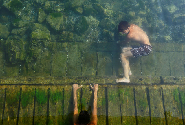 Boys swim to cool off in the waters of the river Drim in Struga, Macedonia August 5, 2017. (Photo by Ognen Teofilovski/Reuters)