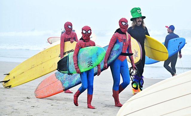 Surfers arrive in costume to surf the waves on a foggy morning at Newport Beach, California, on October 26, 2024 continuing an annual tradition of surfing in costumes here on the last Saturday before Halloween. (Photo by Frederic J. Brown/AFP Photo)