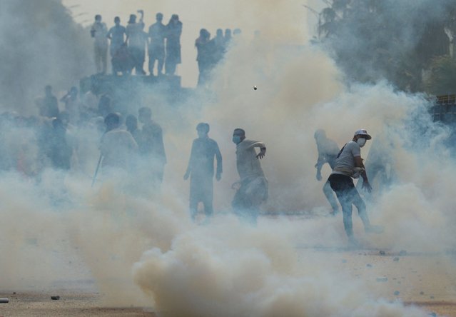 A supporter of jailed former Pakistani Prime Minister Imran Khan's party, the Pakistan Tehreek-e-Insaf (PTI), throws back a tear gas shell during an anti-government rally in Islamabad, Pakistan, on October 5, 2024. (Photo by M Asim/Reuters)