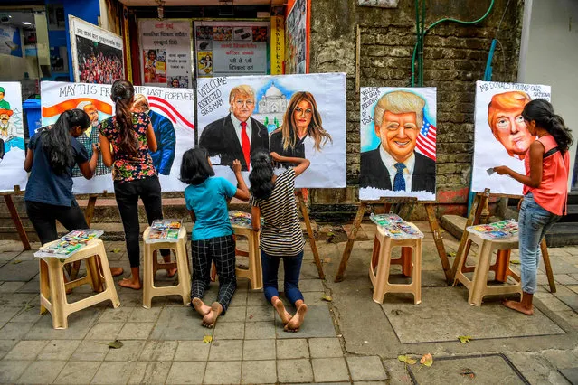 Students paint on canvas faces of US President Donald Trump and his wife Melania in the street in Mumbai on February 21, 2020, ahead of the visit of US President in India. (Photo by Indranil Mukherjee/AFP Photo)