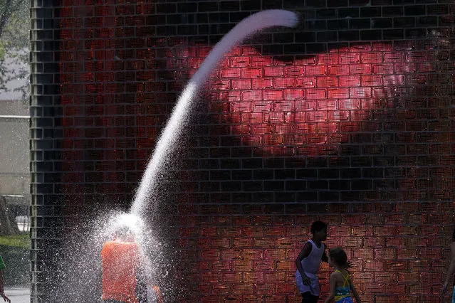 Children play in the Crown Fountain at Millennium Park in Chicago, Wednesday, June 29, 2022. (Photo by Nam Y. Huh/AP Photo)