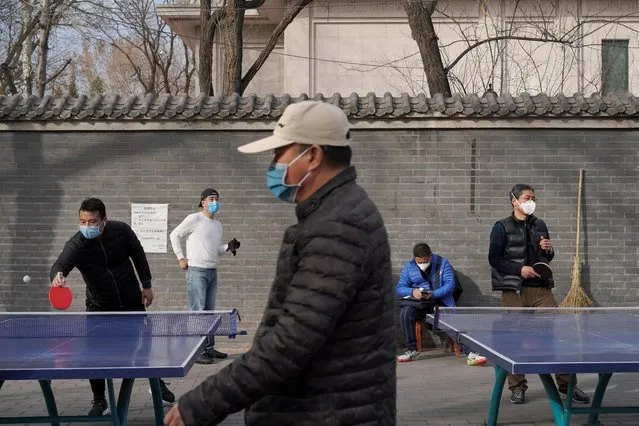 People wearing face masks play table tennis at a park in Beijing, China on February 21, 2020. (Photo by Reuters/China Stringer Network)