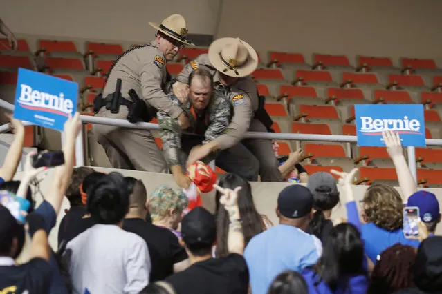 Supporters of U.S. Democratic presidential candidate Bernie Sanders react as law enforcement officers wrestle with a supporter of U.S. President Donald Trump at a rally in Phoenix, Arizona, U.S. March 5, 2020. (Photo by Lucas Jackson/Reuters)