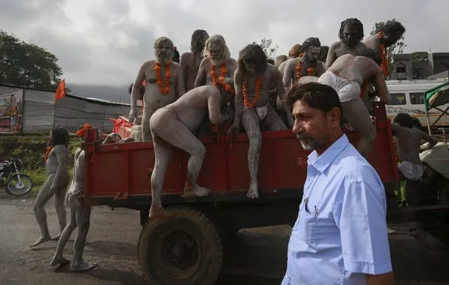 Naga Sadhus, or Hindu holy men, arrive at a camp before a procession during Kumbh Mela or the Pitcher Festival in Trimbakeshwar, India, August 27, 2015. Hundreds of thousands of Hindus took part in the religious gathering at the banks of the Godavari river in Nashik city at the festival, which is held every 12 years in different Indian cities. (Photo by Danish Siddiqui/Reuters)