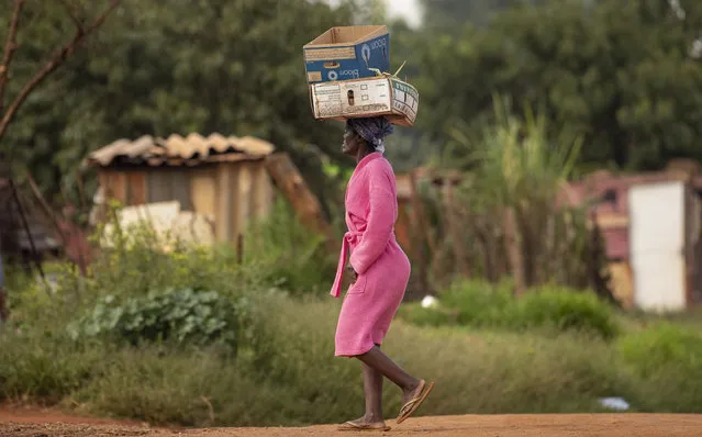 A woman carrying boxes on her head at a informal settlement, east of Johannesburg, South Africa, Friday, March 27, 2020. (Photo by Themba Hadebe/AP Photo)