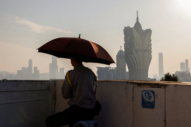 A security guard sits in front of the Grand Lisboa casino operated by SJM Holdings, in Macau, China on December 17, 2024. (Photo by Tyrone Siu/Reuters)